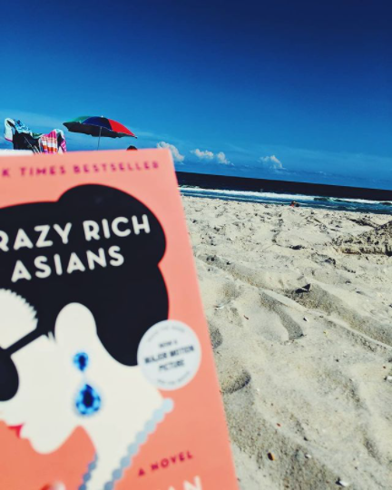 2020 summer reading bookCrazy Rich Asians by Kevin Kwan posed on a LBI Region beach