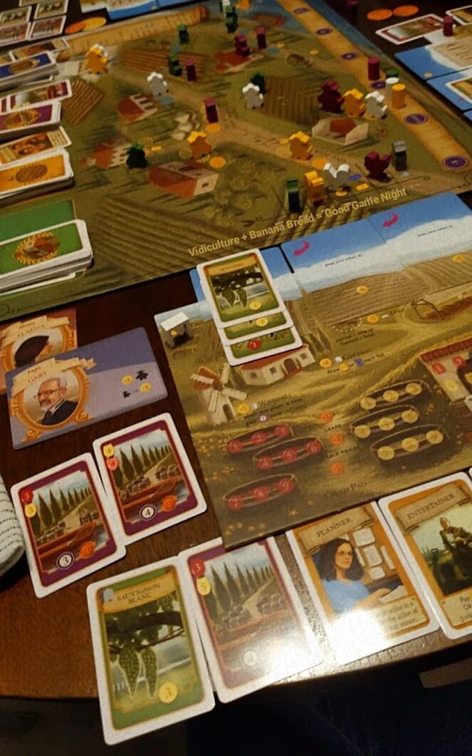 brown table with cards and play pieces from board game Viticulture